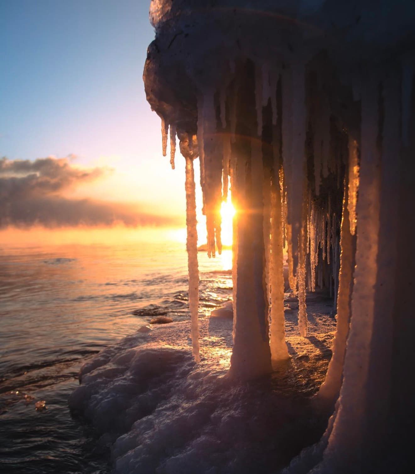 Sunset light through icicles hanging over Lake Superior near Duluth