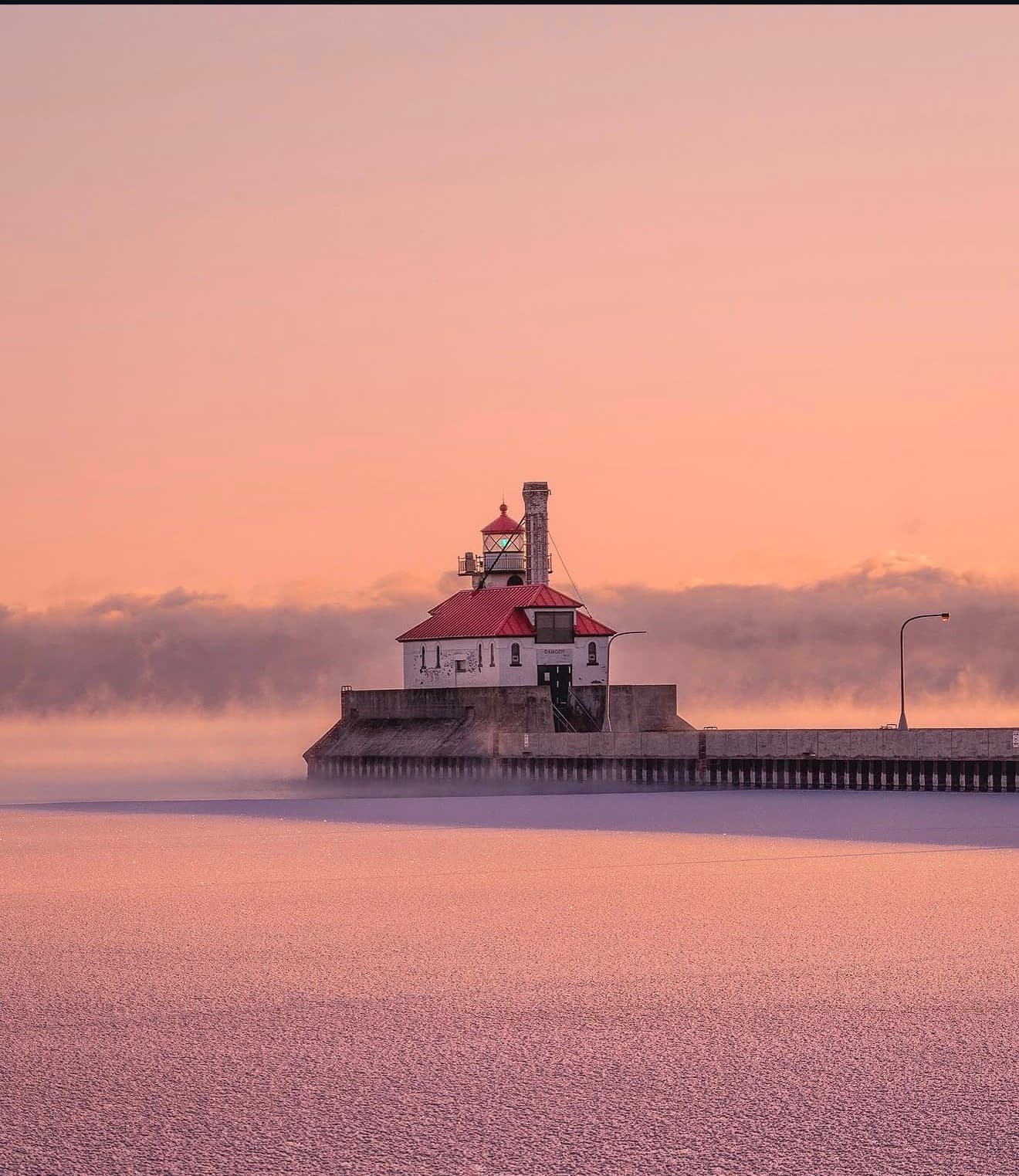 Duluth South Breakwater lighthouse emerging from lake-effect fog at dawn